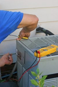 technician working on the outdoor unit of an air conditioner