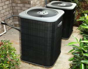 Two outdoor ac units sitting on concrete