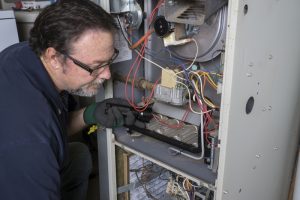 technician-looking-at-inside-of-furnace