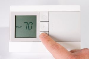 hand-adjusting-digital-thermostat