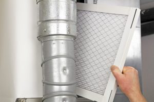 homeowner-putting-clean-air-filter-in