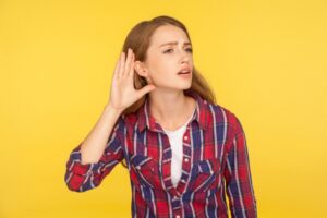 woman-holding-hand-to-ear-listening-closely