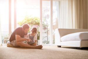 dad-and-daughter-sitting-in-living-room-with-sun-shining-in