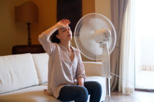 woman-sitting-in-front-of-fan-looking-hot