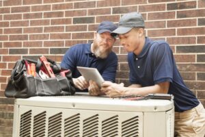 two-technicians-working-on-air-conditioner