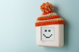 thermostat-wearing-a-hat-and-displaying-a-smiley-face